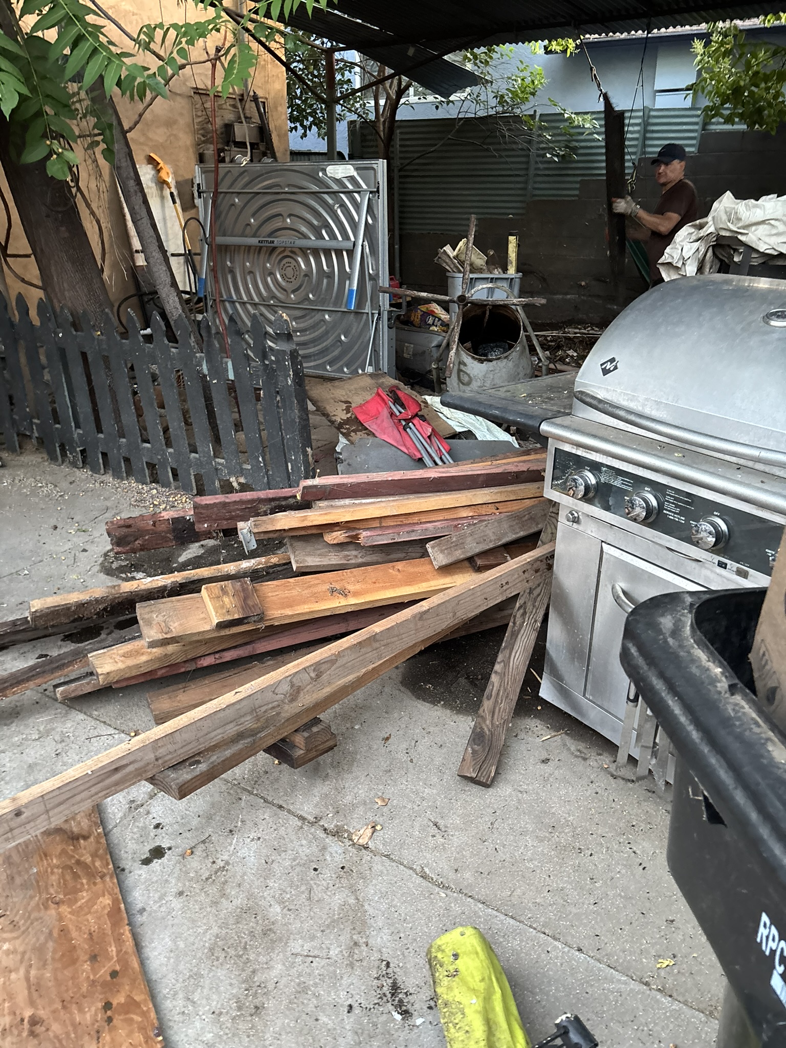 Crew removing lumber, appliances, and debris — property cleanup in progress